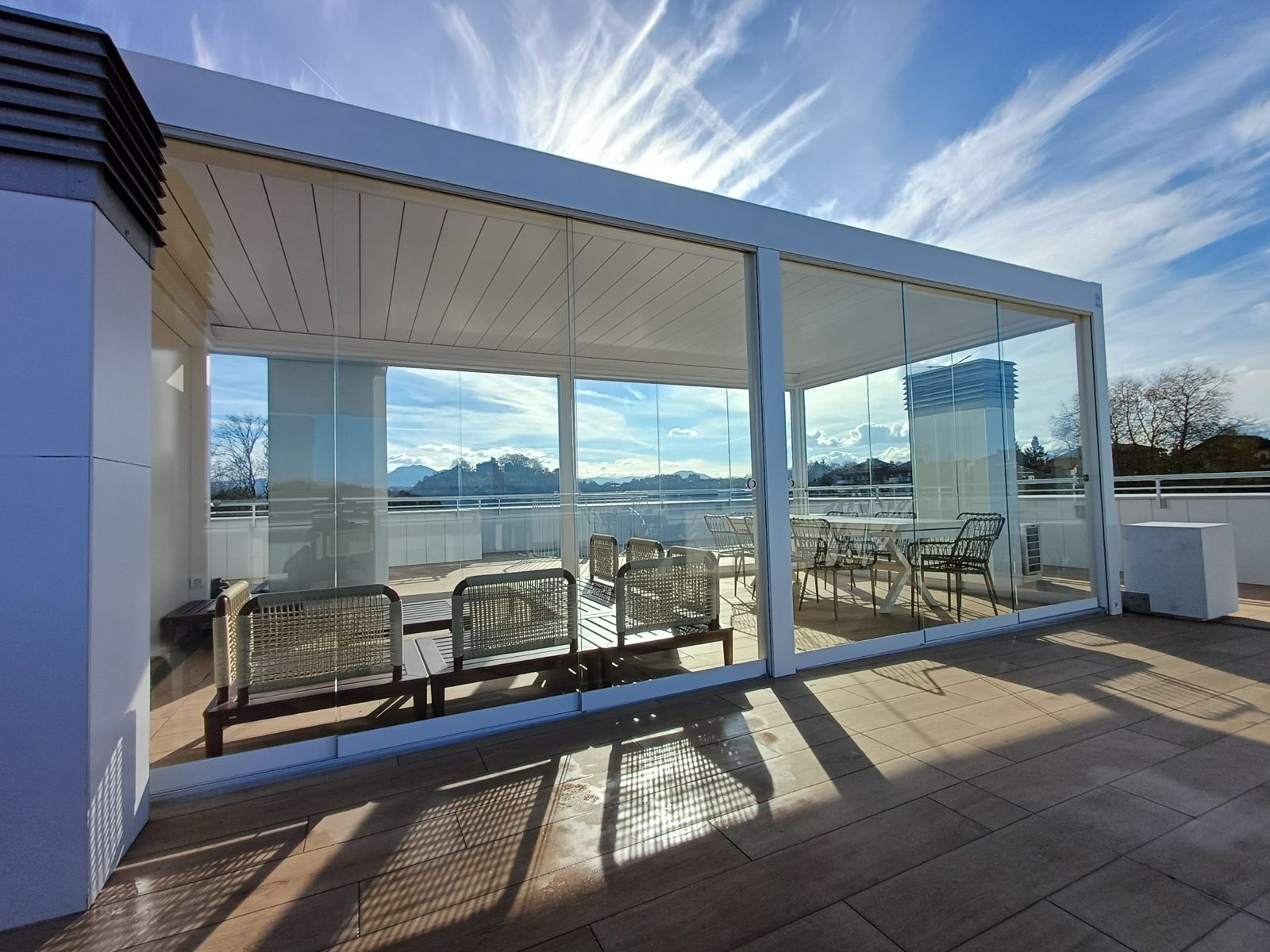 Ático con pérgola bioclimática blanca cerrada con correderas de cristal