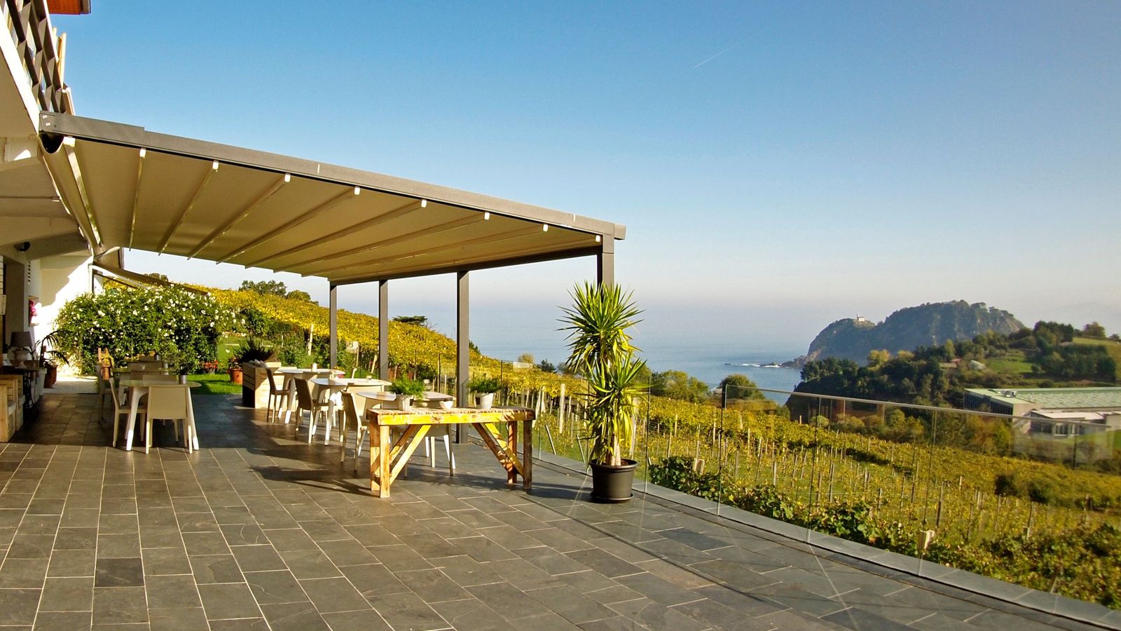 Terraza con vistas al mar cubierta con una pérgola de lona tensada con caída
